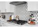 Modern kitchen featuring sleek countertops, stainless steel appliances, and a stylish tile backsplash above the gas range at 257 Rawhide Dr, Louisburg, NC 27549