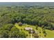 Drone shot of house nestled in a green wooded area, highlighting a tranquil setting at 3000 Hidden Spring Ln, Oxford, NC 27565