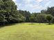 Expansive backyard with lush green grass, mature trees, and a fenced perimeter at 3000 Hidden Spring Ln, Oxford, NC 27565
