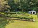 Aerial view of the backyard vineyard, trampoline, storage building, and lawn at 3000 Hidden Spring Ln, Oxford, NC 27565