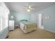 A bright bedroom featuring a ceiling fan, a cozy bed, and an adjacent bathroom entrance at 3000 Hidden Spring Ln, Oxford, NC 27565