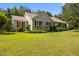 Well-maintained single-story home with a lush front lawn, red shutters, and mature landscaping at 3000 Hidden Spring Ln, Oxford, NC 27565
