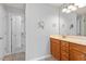 Bright bathroom featuring a wooden vanity, a mirror, and a walk in closet at 3021 Winding Waters Way, Raleigh, NC 27614
