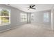 Spacious bedroom with neutral carpet, ceiling fan, and large windows offering ample natural light at 3021 Winding Waters Way, Raleigh, NC 27614