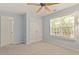 Bedroom features neutral carpet, a ceiling fan, a window, and a closet at 3021 Winding Waters Way, Raleigh, NC 27614