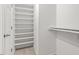 Bright walk-in closet featuring white walls, carpet, and white shelving for storage at 3021 Winding Waters Way, Raleigh, NC 27614