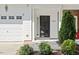 Up close view of a front door with tidy bushes and an attached single car garage at 3021 Winding Waters Way, Raleigh, NC 27614