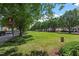 The community green space has a long grassy area lined with trees to provide shade to the adjacent sidewalks at 3021 Winding Waters Way, Raleigh, NC 27614