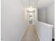 A long hallway with neutral-toned walls and carpet, lit by recessed lighting and illuminated by natural light at 3021 Winding Waters Way, Raleigh, NC 27614