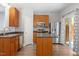 Well-lit kitchen with stainless steel refrigerator, oven, microwave and island with a door leading to the outside at 3021 Winding Waters Way, Raleigh, NC 27614