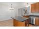 Charming kitchen featuring wooden cabinets, a stainless steel dishwasher, and a modern hanging light fixture at 3021 Winding Waters Way, Raleigh, NC 27614