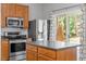 Cozy kitchen offering stainless steel appliances, wooden cabinetry, and a sliding glass door to the outside at 3021 Winding Waters Way, Raleigh, NC 27614