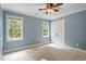 Cozy bedroom featuring soft blue walls, white trim, and two windows allowing ample natural light at 3025 Bentwillow Dr, Fuquay Varina, NC 27526