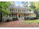 Two-story home with a welcoming front porch, complemented by lush landscaping and mature trees at 3025 Bentwillow Dr, Fuquay Varina, NC 27526