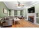 Comfortable living room featuring a fireplace, hardwood floors, and bright windows for natural light at 3025 Bentwillow Dr, Fuquay Varina, NC 27526