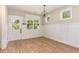 Classic dining area with wainscoting, LVP floors, a modern light fixture, and a door to the backyard at 303 Godwin St, Selma, NC 27576