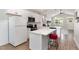 Clean, white kitchen features stainless appliances, tile backsplash, island seating and hardwood floors at 303 Godwin St, Selma, NC 27576