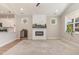 Inviting living room with fireplace, mantel, large rug and multiple windows to let the sunshine in at 303 Godwin St, Selma, NC 27576