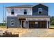 New two-story home shows blue siding, windows, and a two-car garage under construction at 311 Thistle Patch Pl, Angier, NC 27501