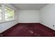 Bedroom with large window and red carpet at 3204 Friar Tuck Rd Rd, Raleigh, NC 27610