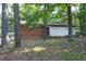 Rear view of a brick single story house surrounded by trees at 3204 Friar Tuck Rd Rd, Raleigh, NC 27610