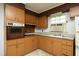 Classic kitchen showcasing cabinetry, oven, countertop, and a window unit for cooling, ready for a modern update at 3204 Friar Tuck Rd Rd, Raleigh, NC 27610