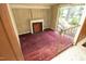 View of the cozy living room featuring classic fireplace, wood walls, and natural light through a sliding glass door at 3204 Friar Tuck Rd Rd, Raleigh, NC 27610