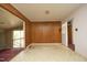 Living room with wood paneling and worn carpet at 3204 Friar Tuck Rd Rd, Raleigh, NC 27610