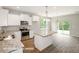 Bright, open kitchen with an island, stainless steel appliances, and a view of the backyard at 348 Danube Dr, Zebulon, NC 27597