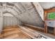 Unfinished attic space features exposed rafters, insulation, a window, and wood flooring materials for a custom build at 3506 Arthur Minnis Rd, Hillsborough, NC 27278