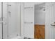 Bathroom showcasing a tiled shower and doorway to a room with hardwood floors, and neutral walls at 3506 Arthur Minnis Rd, Hillsborough, NC 27278