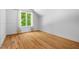 Cozy bedroom featuring hardwood floors, a large window with natural light, and white walls at 3506 Arthur Minnis Rd, Hillsborough, NC 27278
