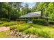 Inviting home with a welcoming porch, surrounded by beautiful landscaping and mature trees at 3506 Arthur Minnis Rd, Hillsborough, NC 27278