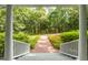 View from the front porch highlighting the brick walkway, lush landscaping, and peaceful surroundings at 3506 Arthur Minnis Rd, Hillsborough, NC 27278