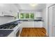 Well-lit kitchen with white cabinets, modern appliances, and a view of the trees at 3506 Arthur Minnis Rd, Hillsborough, NC 27278