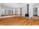 Spacious living room with hardwood floors, a cozy fireplace, and easy access to other rooms at 3506 Arthur Minnis Rd, Hillsborough, NC 27278