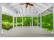 Enclosed porch with white interior and views of the surrounding lush greenery and landscaping at 3506 Arthur Minnis Rd, Hillsborough, NC 27278