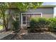 Exterior view of the backyard featuring a screened-in porch and a cozy hammock setup amid lush greenery at 3601 Lily Orchard Way, Apex, NC 27539