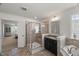 Bright bathroom featuring a glass enclosed shower, soaking tub, granite vanity, and access to the main bedroom at 3601 Lily Orchard Way, Apex, NC 27539