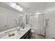 Bathroom featuring a shower-tub combo, dark vanity, and ample counter space at 3601 Lily Orchard Way, Apex, NC 27539