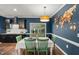 Dining area features a modern light fixture, colorful wall decor, and backyard view at 3601 Lily Orchard Way, Apex, NC 27539