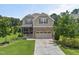 Inviting two-story home with a stone and siding facade, complemented by a well-kept lawn and landscaping at 3601 Lily Orchard Way, Apex, NC 27539