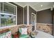 Inviting front porch with stone accents, comfortable seating, and charming decor at 3601 Lily Orchard Way, Apex, NC 27539