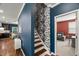 Stylish hallway with staircase, hardwood floors, and designer wallpaper, leading to multiple rooms at 3601 Lily Orchard Way, Apex, NC 27539