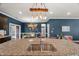 Close-up view of kitchen island featuring granite countertop, stainless steel sink, and pendant lighting at 3601 Lily Orchard Way, Apex, NC 27539