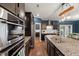 Modern kitchen boasts stainless steel appliances, granite countertops, and sleek dark cabinetry at 3601 Lily Orchard Way, Apex, NC 27539