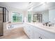 Bathroom includes a soaking tub, glass shower, double vanity, and natural lighting from the window at 429 Carolina Cir, Durham, NC 27707