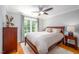 Bedroom with hardwood floors, ceiling fan, area rug, large windows, and warm inviting tones at 429 Carolina Cir, Durham, NC 27707