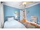 Blue bedroom with ceiling fan, hardwood floors, white trim, and a doorway to an adjacent room at 429 Carolina Cir, Durham, NC 27707