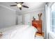 Cozy bedroom featuring a ceiling fan, a wooden dresser, and a sunny window at 429 Carolina Cir, Durham, NC 27707